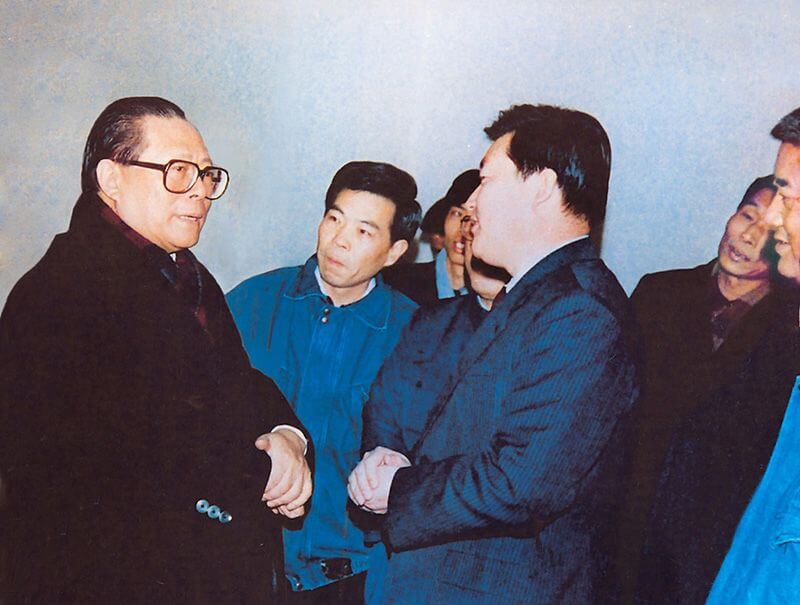 1991年2月5日，时任中共中央总书记的江 泽 民（左一）视察CC国际，他批示：“抓住机缘，深入鼎新，扩大盛开，推进发展，维持不变。”